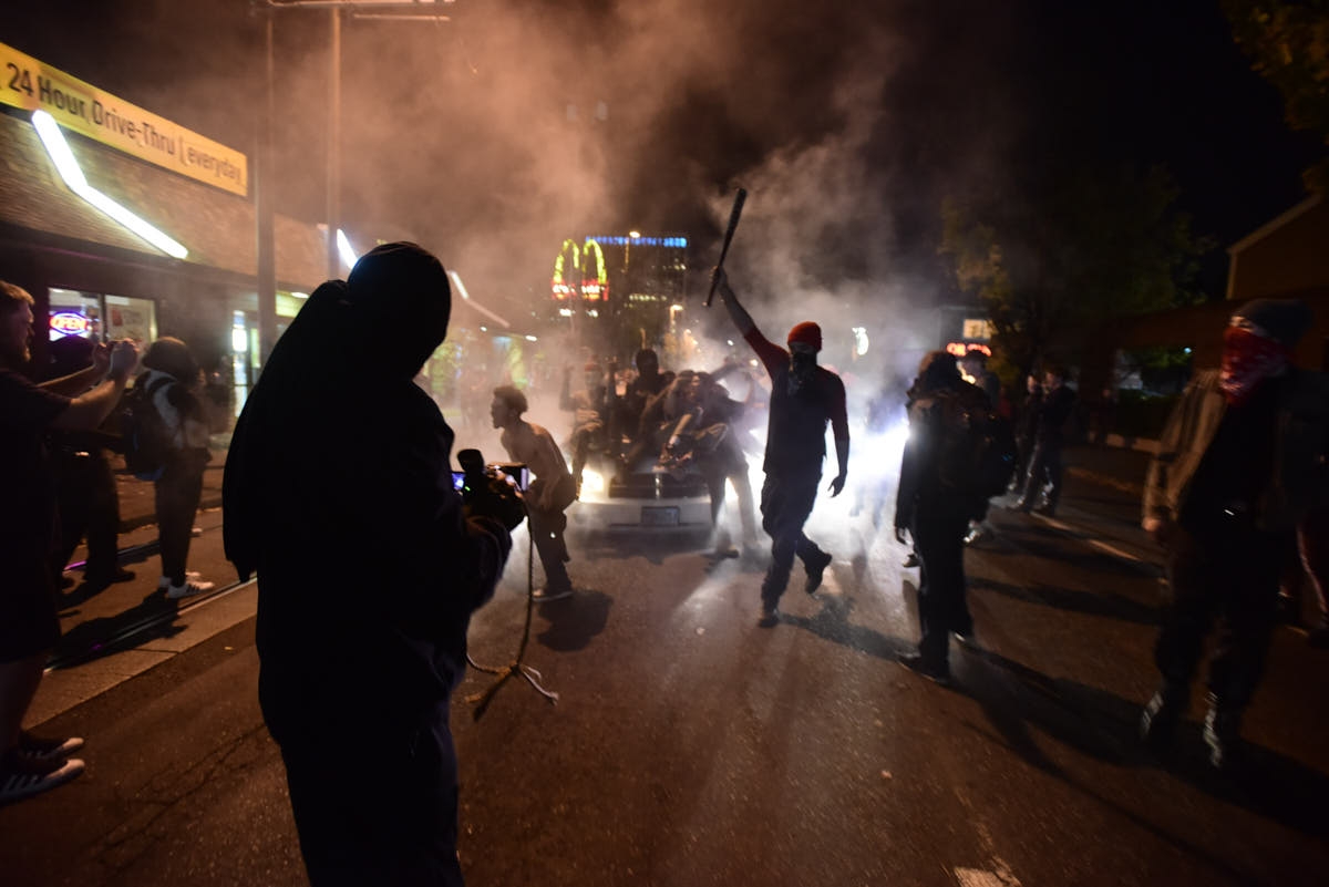 Portland, USA. 29th May, 2020. Protesters walk by graffiti on the Louis  Vuitton store in Portland, Ore., on May 29, 2020. (Photo by Alex Milan  Tracy/Sipa USA) Credit: Sipa USA/Alamy Live News